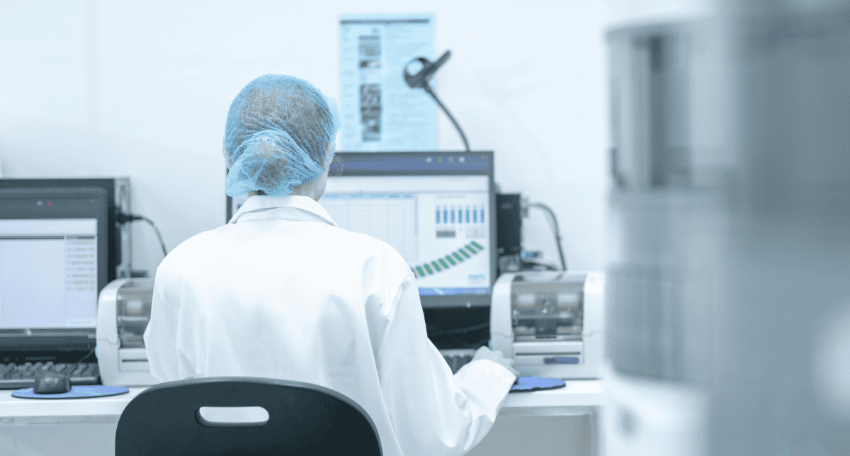 A lab scientist reviews automated analysis results at a workstation.